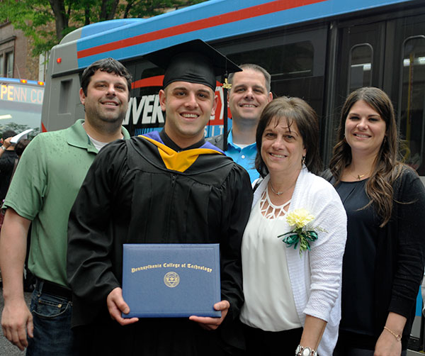 The family of Adam T. Engel, of South Williamsport, who graduated in business administration: marketing concentration, gathers in the drizzle for a group photo – only a fraction of the group, in fact, that was on hand for his commencement. 