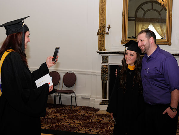 Katelyn M.McNaughton, of Malvern, snaps a photo of Kimberly R.Martinez, of Jersey Shore, with Brian D. Walton, assistant dean of business and hospitality.  The women earned degrees in business administration: marketing concentration; Martinez was enrolled in Walton's First Year Experience class in Fall 2012.