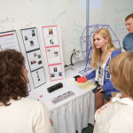 A member of the business Sirens of Sound explains to mentors a smartphone speaker developed by her company during the Wildcat Den Showcase.