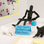 A team shows off samples of 3-D printed toys, part of its week’s work.
