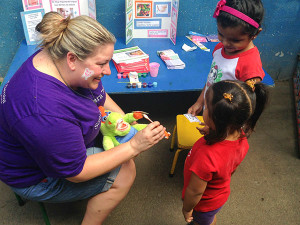 Penn College dental hygiene: health policy and administration concentration student Carrie M. Derk, of Chambersburg, offers a demonstration of proper tooth-brushing technique to children in the Santo Domingo neighborhood of Managua, Nicaragua. (Photo provided)