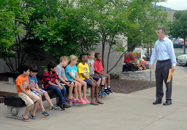 Michael J. Reed, interim dean of science, humanities and visual communications, welcomes children to campus with an enticing preview of the excitement and opportunity that lay ahead. His family was a Fresh Air host and among those accompanying the group on Monday's tour.