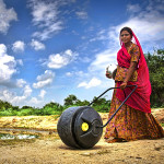 A woman demonstrates WaterWheel 2.5, a rolling water tank that eases the daily burden of fetching water in rural India. Photo courtesy of Wello