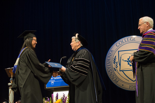 With state Sen. Gene Yaw, chairman of the college's board of directors, waiting to add his best wishes, a graduate is congratulated by President Davie Jane Gilmour.