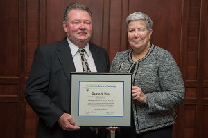 Warren A. Peter receives the Distinguished Alumni Award from Davie Jane Gilmour, president of Pennsylvania College of Technology, at the college’s Summer 2015 commencement ceremonies. 