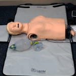 A "patient" awaits a hands-on CPR session offered by Laerdal's Kevin Webb. 