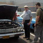 Club member Dave Cavagnaro discusses his four-door 1962 Chevrolet Impala sedan with a student.