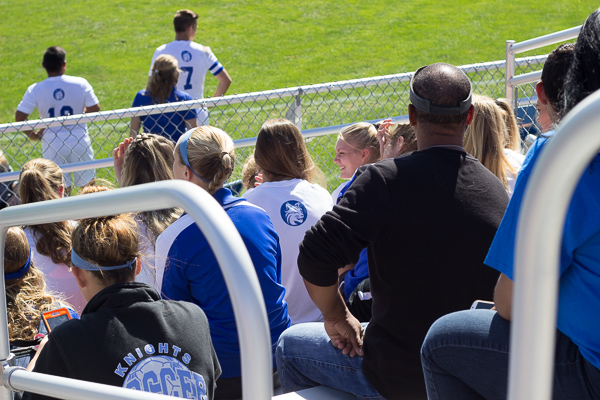 Awaiting their time on the field, Wildcat women watch the men's game from the stands.