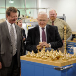 Brass candlesticks pique the lawmakers' interest during a stop in the automated manufacturing lab.