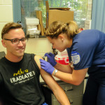 Engaging in participatory journalism, student photographer Caleb G. Schirmer – an applied management major from Sugarloaf – is vaccinated by Haylea D. Estright, of Brisbin.
