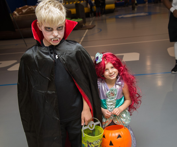 Scary and sweet: the son and daughter (vampire and Ariel) of Lindsay R. Derrick, an alumna and nursing student, are among the eager early arrivals to the Field House festivities. 