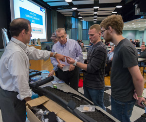 Blair Soars (left), president of Pneu-Dart Inc., talks with Penn College students and C. Hank White (second from left), director of the Plastics Innovation & Resource Center, during a recent Manufacturing Day program.