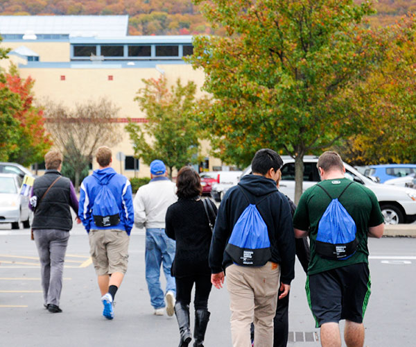 Bearing check-in backpacks full of tools for their journey, prospective students traverse campus.