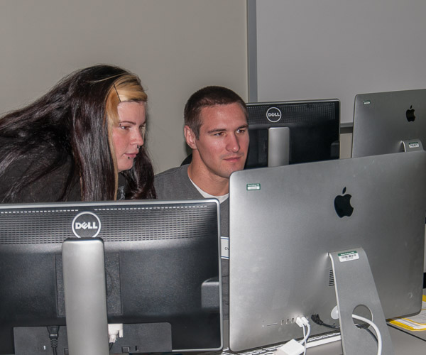A Penn College student (left) helps a high schooler to navigate animation software in a visual communications lab.