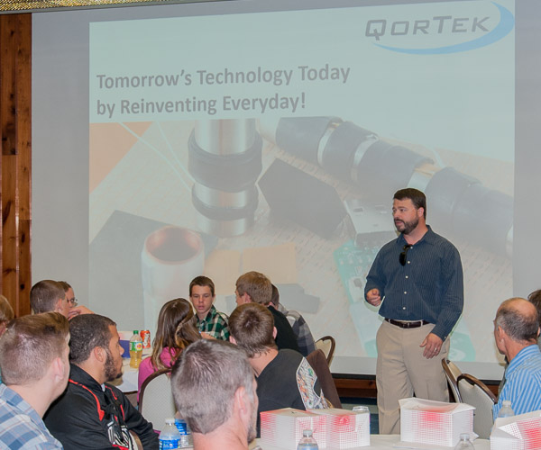 Ross Bird, a 2001 Penn College graduate and president of QorTek Inc., shows students its IntelliPlastics product, which was developed for the military. His company’s problem: How can the material be used by other companies (thus growing QorTek’s customer base)?