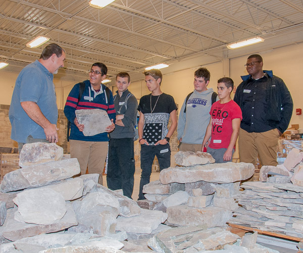 With building construction masonry instructor Glenn R. Luse, students from Monroe Career & Technical Institute check out the supply of natural stone harvested from a local mountain. 