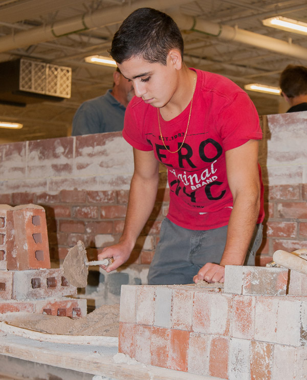 A student from Monroe Career & Technical Institute puts trowel to mortar in the Construction Masonry Building.