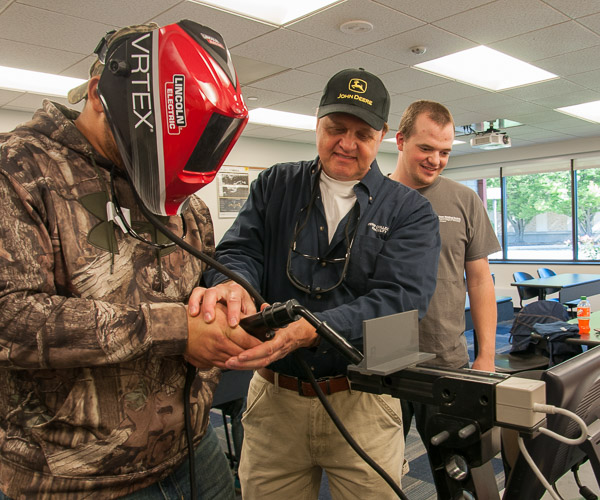 Timothy S. Turnbach, instructor of welding, guides a Jersey Shore Area High School student in using the college’s virtual welder.