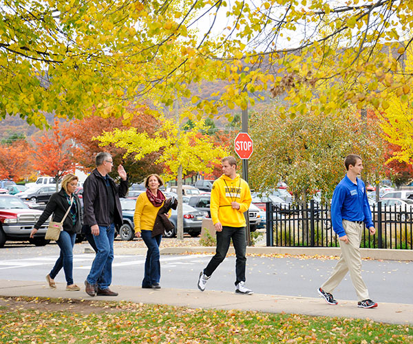 In colors coordinated with nature, a family tours campus with Ambassador Bryan M. Behm.