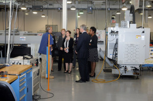 Instructor John M. Good leads a tour of Pennsylvania College of Technology’s automated manufacturing lab for a group that includes Patrick T. Harker, president and CEO of the Federal Reserve Bank of Philadelphia. From left are Good; Erica R. Mulberger (hidden), executive director of the Central Pennsylvania Workforce Development Corp.; Shannon M. Munro, executive director of Workforce Development & Continuing Education at Penn College; Tracy L. Brundage, the college’s vice president of workforce development; Noelle S. Baldini, Federal Reserve community engagement associate; Harker; Elizabeth H. Lockwood (also hidden), SEDA-COG project development/grants manager and regional coordinator for Partnerships for Regional Economic Performance; and Theresa Y. Singleton, Federal Reserve vice president and community affairs officer.