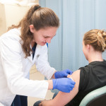 After a reportedly pain-free injection, physician assistant student Jessica A. Gmerek, of Bellefonte, applies an adhesive bandage to Katelin E. Thompson, an occupational therapy assistant major from Osceola Mills. 