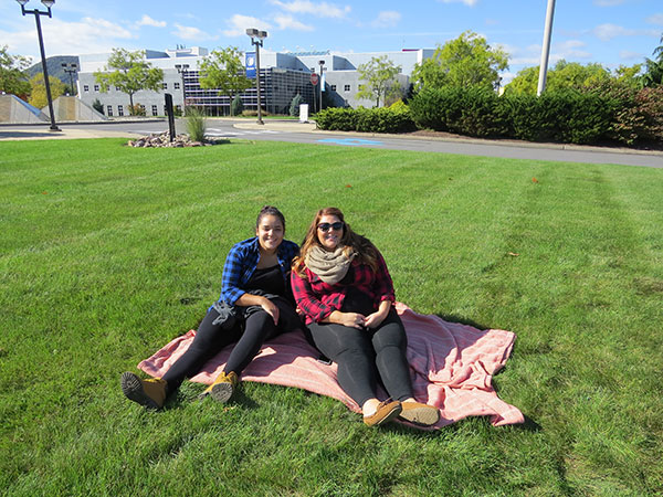 Tania Parra Calderon (left), a first-year nursing student from Arendtsville, joins Juliette R. (Campana) Pena, a 2013 nursing graduate, on the SASC lawn. Pena's husband, Gerardo, who earned two plastics degrees in 2011, was among the Frisbee enthusiasts who turned up for the Homecoming Weekend tradition.