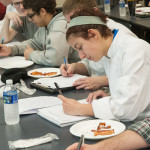 Students make notes on the texture and taste of two brands of bacon.