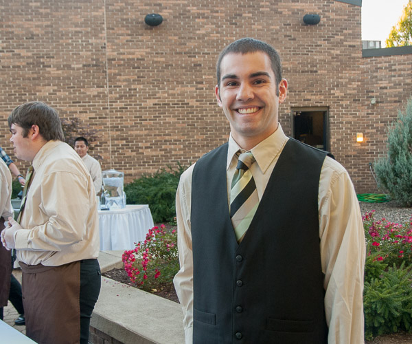 Hospitality management student Christian A. Bell, of Warrington, helps to serve guests at Oktoberfest on the Thompson Professional Development Center patio. The event was catered by the Catering class.