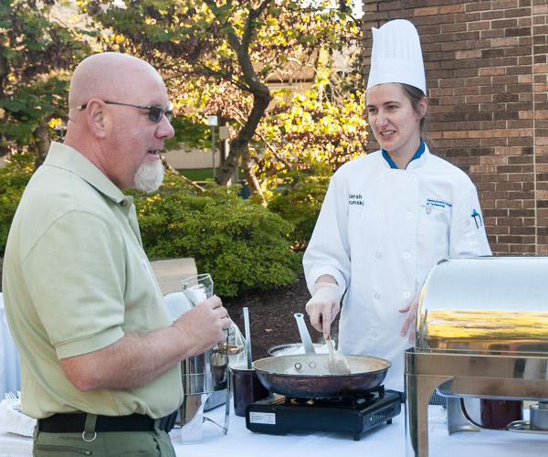 Culinary arts and systems student Sarah A. Brunski, of Mount Holly Springs, serves spaetzle, a traditional German noodle dish, to a WACC alumnus.