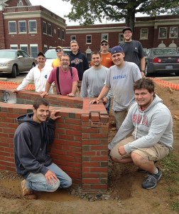 A “Penn College 2015” brick signifies the workmanship by instructor Glenn R. Luse (in suspenders) and nine students from his Advanced Masonry class, who constructed accessible flower beds at the Lysock View Complex.