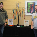 Penn College veterans John A. Gondy (left), an architectural technology major from Glenmoore, and Jacob M. Heuman, a building automation technology student from Boiling Springs, staff the Veterans Club "Giving Tree" Tuesday night.
