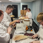 Behind the scenes, students Courtney K. Brown, of Hanover; Jeffrey L. Bretz, of Quakertown, Lloyd A. Shope, of Blanchard, prepare sample boxes of Guittard Chocolate.