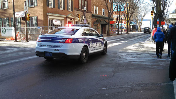 A Penn College Police cruiser helps escort walkers near West Fourth and William streets.