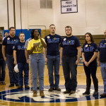 Gwendolyn A. Ntim, a health arts: practical nursing emphasis major from Yonkers, New York, delivers a rendition of the national anthem, surrounded by members of the Omega Delta Sigma veterans fraternity.