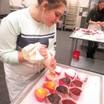 Ally T. Monborne (foreground), of Williamsport, and Sarah I. Tielmann, of Tatamy, add a personal touch to their holiday creations.