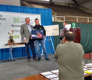 Aaryn C. Hoy is presented with a Husqvarna chain saw that he won for Penn College's School of Transportation & Natural Resources Technologies.
