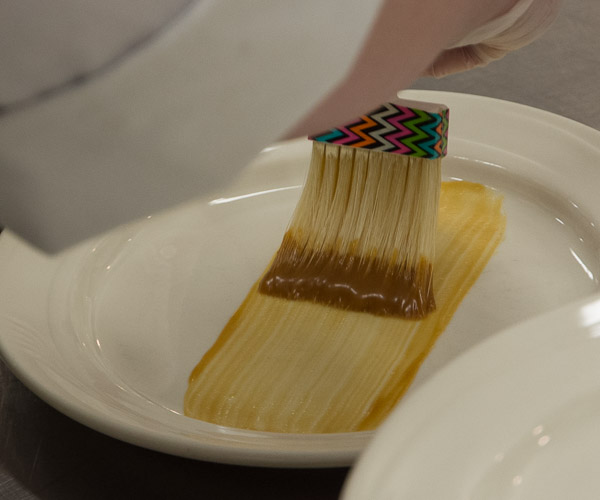 Student Kayla M. Peters, of Pine Grove, artfully adds bourbon caramel to a plate.