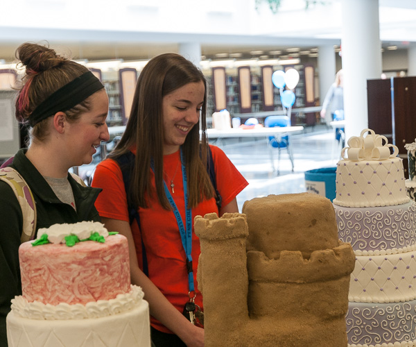Katie M. Weakland (left), a baking and pastry arts major from Pennsylvania Furnace, and Rebekah L. Caretti, of Weedville, enrolled in dental hygiene: health policy and administration concentration, get an eyeful at a library display of student-created wedding cakes.
