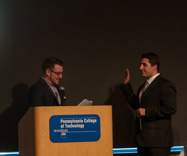 Anthony J. Pace (left), assistant director of student activities for student organizations/orientation, swears in Zachary T. Peachey for a second term as SGA president.