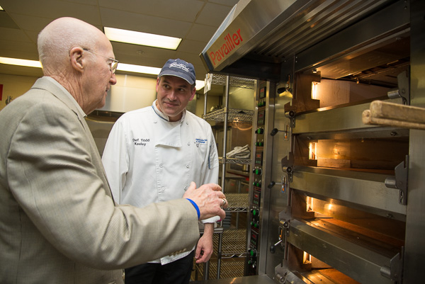 By the glow of the Pavailler baker’s oven, Chef M. Todd Keeley, instructor of baking and pastry/culinary, and Robert Fries, ’45, aviation mechanics, talk shop. 