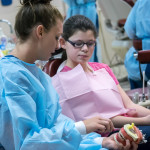 Using one of the clinic's helpful models, Brieona R. Broadwater, of Berlin, explains proper dental hygiene to Emma Mitchell.