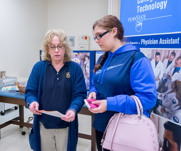 An Open House visitor reviews curriculum with Christine N. Kessler (left), associate professor of physician assistant.