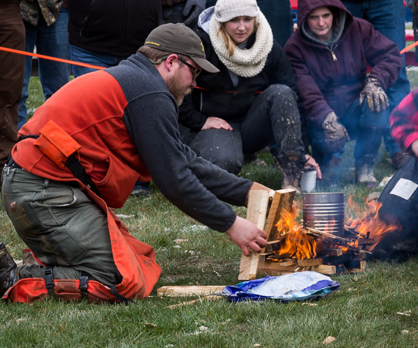 With silent support from classmate Harley R. Heichel (in purple jacket), of Wellsboro, Paul M. George keeps the home fire burning. 
