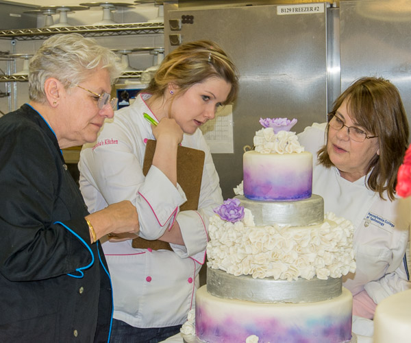 Competition judges check the quality of a student’s work. From left: Kim Morrison, Samantha Gundlach and Sue L. Mayer.<br />
