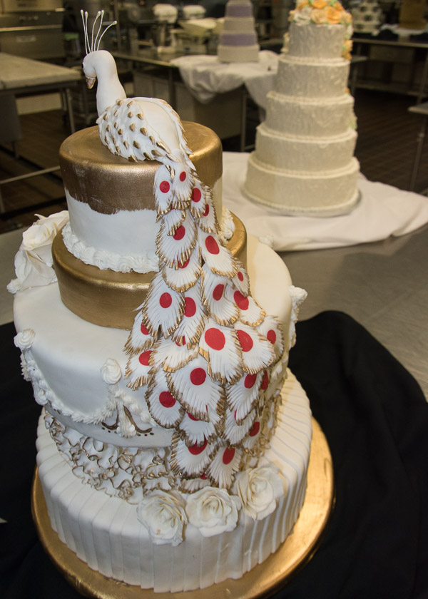 Handmade peacock feathers enhance a cake’s elegance.