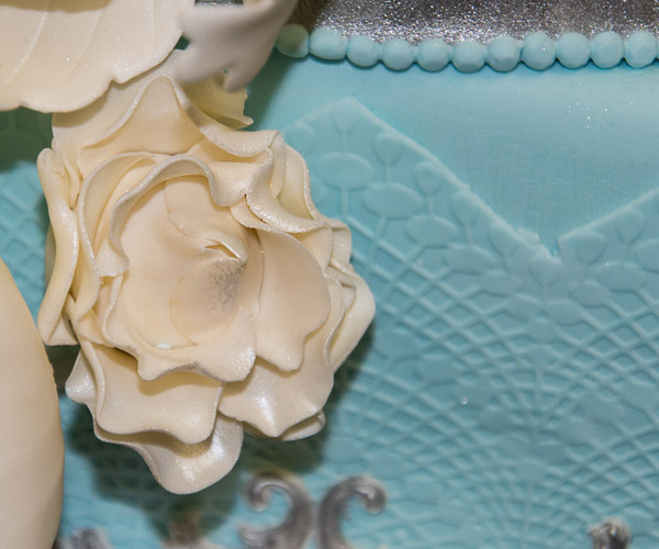 Delicate white peonies jump off a blue “lace” background.