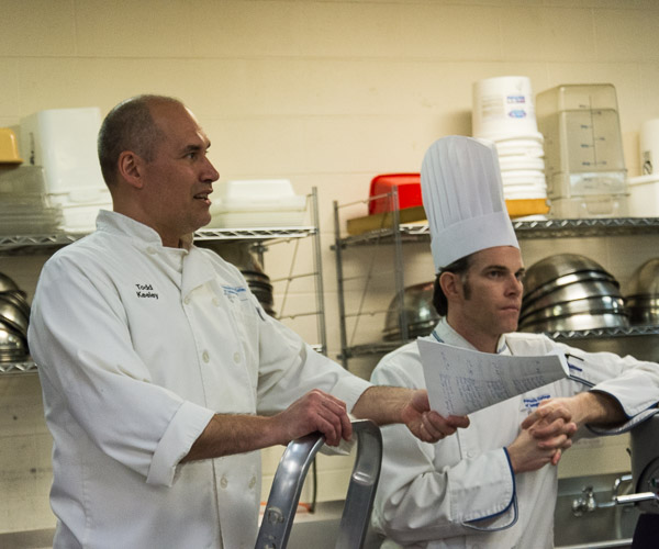 Chefs Todd M. Keeley (left) and Charles R. Niedermyer, instructors of baking and pastry arts/culinary arts, congratulate students.