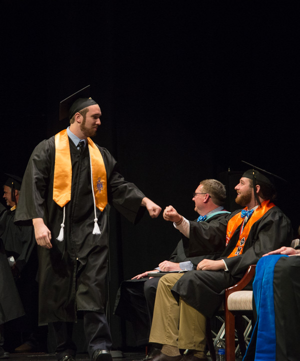 Fist-bumps are plenty as graduates made their way across the stage.