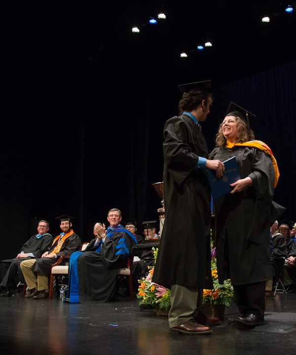 Lauren A. Rhodes, assistant professor of mathematics, awards a diploma to her son, Matthew H. Gordon, a welding and fabrication engineering technology graduate. 