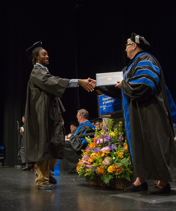 LaQuinn N. Thompson, one of two recipients of the President’s Award for leadership and service to the college, shakes his president’s hand. 